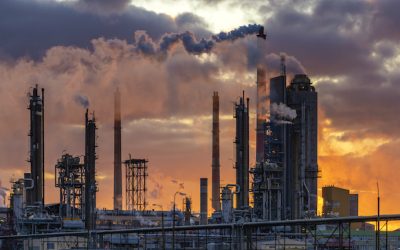 chemical plant at sunrise. Smoke and pollution illuminated by the rays of the rising sun