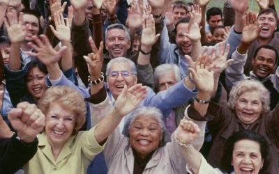 Large group of multi-ethnic people cheering with arms raised