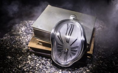 Time Concept. Distorted soft melting clock on a old books, the Persistence of Memory of Salvador Dali. With dark toned foggy background. Selective focus