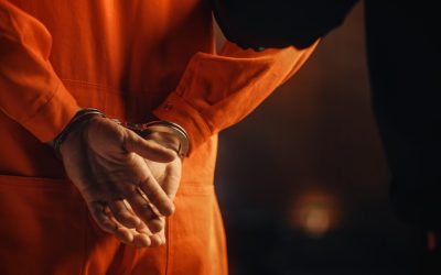 Cinematic Close Up Footage of a Handcuffed Convict at a Law and Justice Court Trial. Handcuffs on Accused Criminal in Orange Jail Jumpsuit. Law Offender Sentenced to Serve Jail Time.