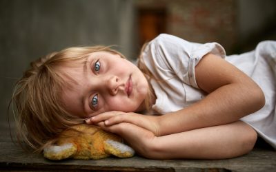 portrait of unfortunate stray kid lying on the board in the dirty alley, shallow depth of field.