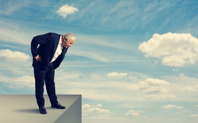 senior businessman standing over the precipice and looking down